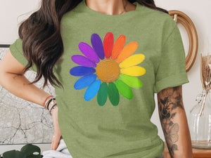 Green t-shirt with a colorful painted daisy design featuring rainbow petals and a gold center.