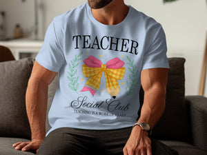 Light blue t-shirt with "TEACHER Social Club" and a pencil bow graphic.