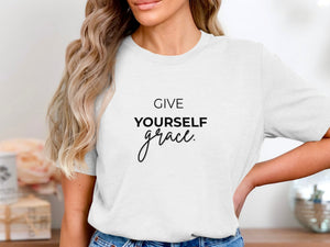 White t-shirt with black text that reads "GIVE YOURSELF grace."