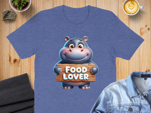 Cartoon hippo holds wooden sign reading "FOOD LOVER" on a t-shirt.