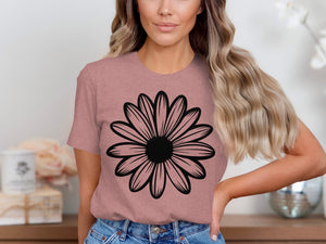 Woman wearing a dusty rose t-shirt with a black outline daisy graphic.