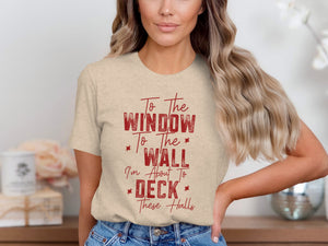 Light beige t-shirt with red text "To the window to the wall I'm about to deck these halls".