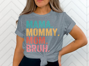 Gray t-shirt with text "MAMA. MOMMY. MOM. BRUH." in teal, gold, coral, and pink.