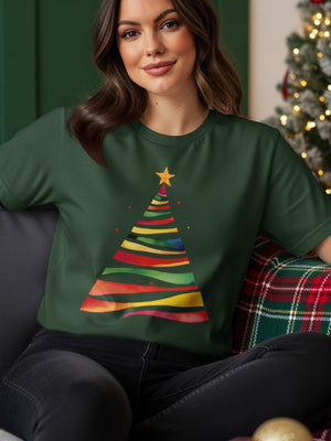 Woman wearing a green t-shirt with a colorful watercolor Christmas tree graphic.