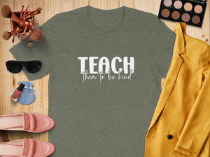 Green t-shirt with white text "TEACH them to be kind."