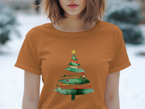 Orange t-shirt with a watercolor Christmas tree graphic and a yellow star.