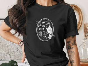 Black t-shirt with white Costa Rica toucan and hibiscus design in oval frame.