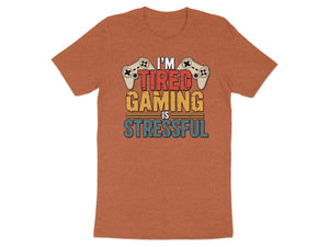 Orange t-shirt with text "I'm tired gaming is stressful" and game controllers.
