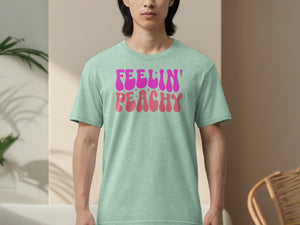 Light green t-shirt with "Feelin' Peachy" graphic in pink and coral.