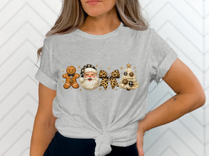 Gingerbread man, Santa, bow, and tree graphic on a gray t-shirt.