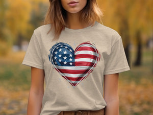 Tan t-shirt with American flag heart graphic and subtle sparkle accents.