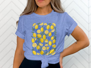Blue t-shirt with a pattern of yellow lemons and green leaves on a blue striped background.