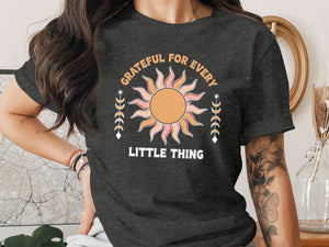 Dark grey t-shirt with "GRATEFUL FOR EVERY LITTLE THING" and sun graphic.