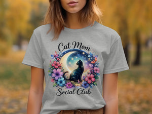 Grey t-shirt with "Cat Mom Social Club" text and a black cat on a moon surrounded by flowers.