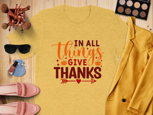 Yellow t-shirt with "IN ALL THINGS GIVE THANKS" text and autumn graphics.