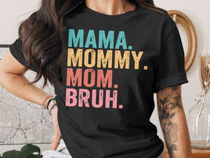 Black t-shirt with "MAMA. MOMMY. MOM. BRUH." text in colorful, distressed lettering.
