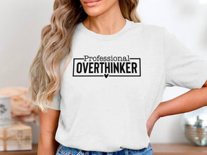 White t-shirt with black text that reads "Professional OVERTHINKER" with a small heart.