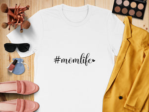 White t-shirt with "#momlife" graphic, surrounded by makeup and accessories.