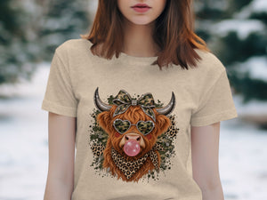 Highland cow with camouflage bow, heart sunglasses, and pink bubblegum.