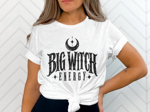 White t-shirt with black text "BIG WITCH ENERGY" and crescent moon graphic.