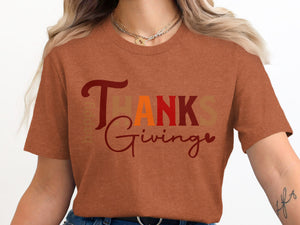 Orange t-shirt with "Happy Thanksgiving" text in varied fonts and colors.