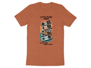 Orange t-shirt with retro video game controllers and text "Let's Play Now!" and "Never Say Game Over!".