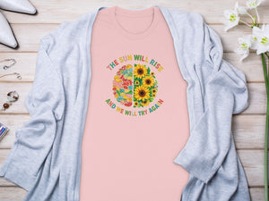 Pink t-shirt with "The sun will rise and we will try again" graphic on a brain design.