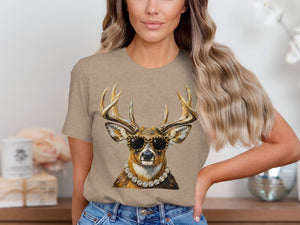 Deer wearing sunglasses and a pearl necklace, printed on a tan t-shirt.