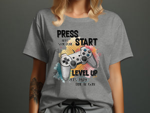 Gray t-shirt with gaming controller and text "PRESS START HAVE SOME FUN! LEVEL UP LET'S PLAY TIME TO WIN".