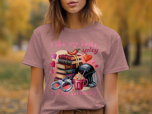 T-shirt graphic with stack of books, chili pepper, handcuffs, iced coffee, and hearts.