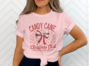 Pink t-shirt with "Candy Cane Christmas Club" and a bow graphic.