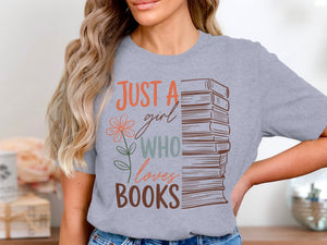 Grey t-shirt with text "JUST A girl WHO loves BOOKS" and stack of books.