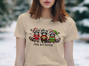 Three raccoons in holiday attire under text that reads "Feral But Festive."