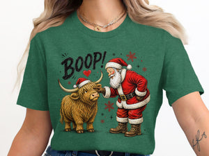 Santa boops a Highland cow with "BOOP!" text on a green t-shirt.