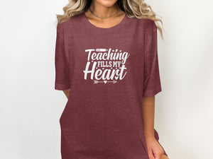Maroon t-shirt with "Teaching Fills My Heart" graphic and small heart and arrows.