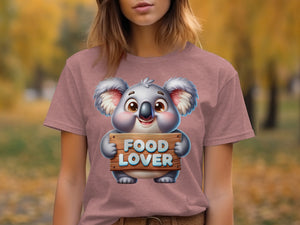 Cartoon koala holds a wooden sign saying "FOOD LOVER" on a t-shirt.