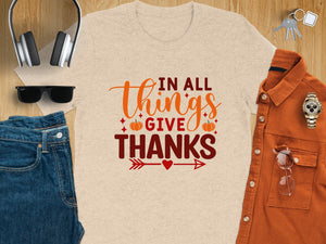 T-shirt with "In All Things Give Thanks" text and fall accents.