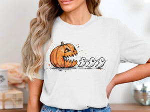White t-shirt with a cartoon pumpkin chasing three ghosts with splatter paint accents.