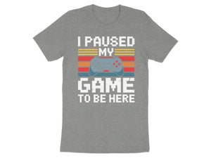Grey t-shirt with "I PAUSED MY GAME TO BE HERE" text and pixelated controller.