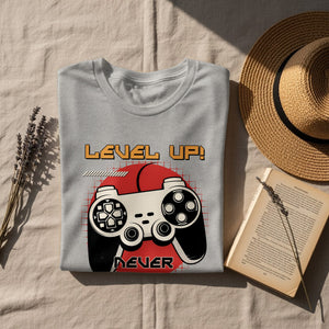 Grey t-shirt with "Level Up! Never" text and vintage video game controller graphic.