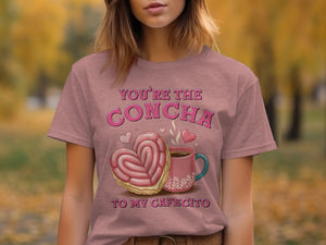 T-shirt with "You're The Concha To My Cafecito" text and heart-shaped concha.