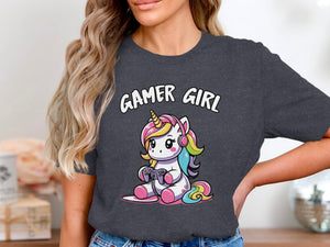Graphic tee with cartoon unicorn wearing headphones and playing video games, text reads "GAMER GIRL".