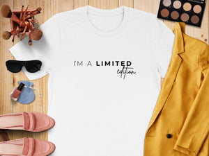 White t-shirt with "I'm a limited edition" text and surrounding accessories.