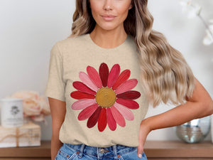 Tan t-shirt with a pink and red painted flower graphic on the chest.