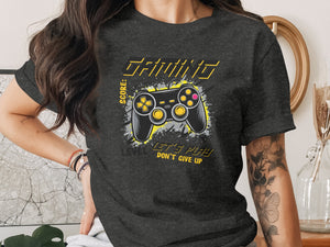 Dark grey t-shirt features a gaming controller graphic and text.