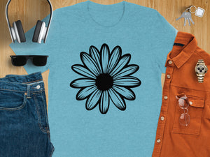 Light blue t-shirt with black daisy graphic, surrounded by jeans, headphones, sunglasses, shirt, watch, keys, and glasses.