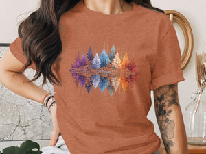 T-shirt with colorful watercolor forest reflection graphic.
