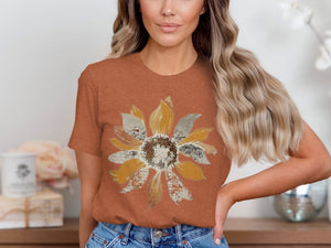 Woman wearing a rust-colored t-shirt with a textured sunflower graphic.