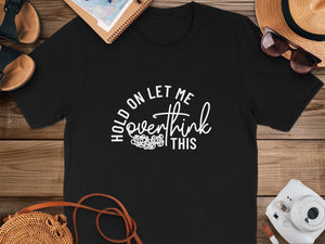 Black t-shirt with white text that reads "Hold on let me overthink this."