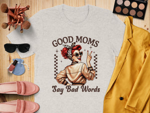 "Good Moms Say Bad Words" graphic on a light gray t-shirt with retro illustration.